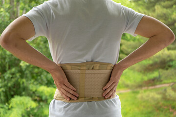 Lumbar corset on the man body. Back brace, orthopedic lumbar, support belt for back muscles