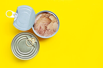 Canned tuna fish on yellow background.