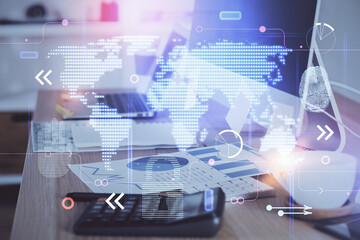 Double exposure of desktop with computer and world map hologram. International data network concept.