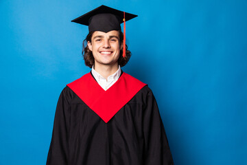 Young graduate man holding degree isolated on blue background