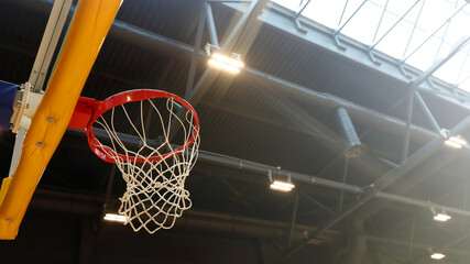Basketball hoop in the sports center against the dark ceiling