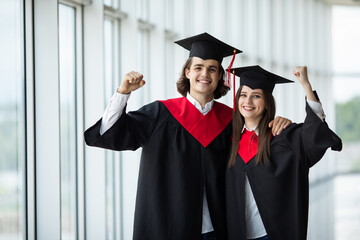 Happy couple of graduates showing diplomas and smiling, Complete high education