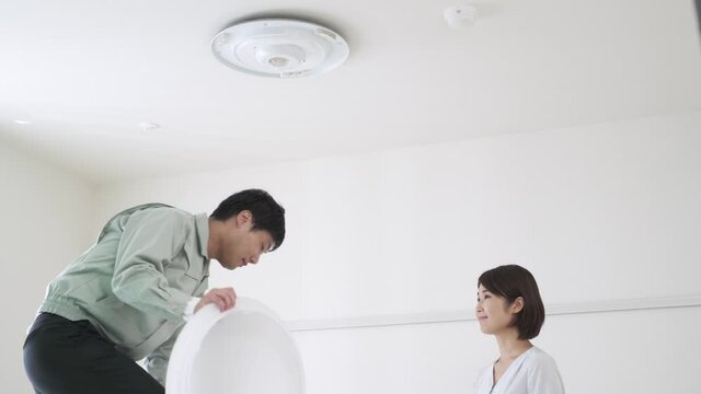 照明器具を取り付ける男性