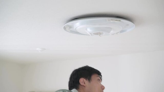 照明器具を取り付ける男性