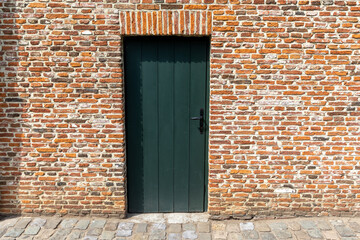 a green door in a red brick wall