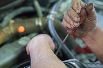 Obraz premium Hands of the car mechanic,repairing the car