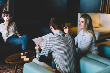 Smiling professional female employee explaining idea of sketch planning to male colleague...