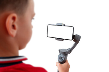 Boy is recording with a mobile phone on the gimbal. Isolated background and phone display for mockup - obrazy, fototapety, plakaty
