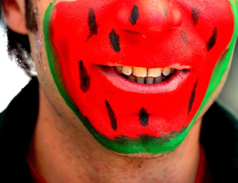Man with painted watermelon face.