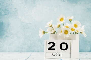 White cube calendar for august decorated with daisy flowers