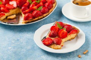Delicious tart with strawberries on a blue painted background. Front view.