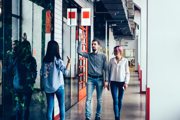 Young friends saying hello with high five gesture at hall of university © BullRun
