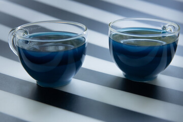 geometry composition, blue butterfly tea with milk on black and white