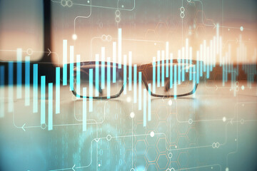 Financial graph hologram with glasses on the table background. Concept of business. Double exposure.