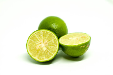 Obraz na płótnie Canvas Closeup Sliced Fresh Lime with One Behind Isolated in White Background