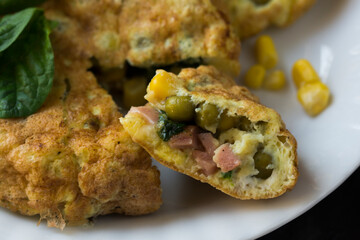 An omelette with sweet corn, green peas and spinach.