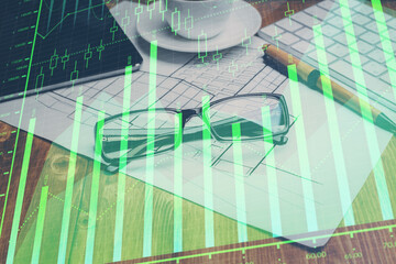 Financial chart hologram with glasses on the table background. Concept of business. Double exposure.