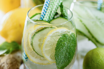Detox refreshing sassy water with cucumber, ginger, mint and lemon in glasses,