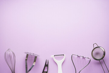 Kitchen utensils with space for text on a purple background. Flat lay.