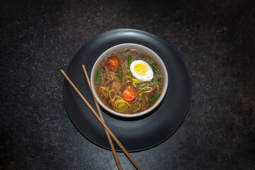 Spicy japanese   soup Bifu Suimono in a white plate. Close up. Side view.