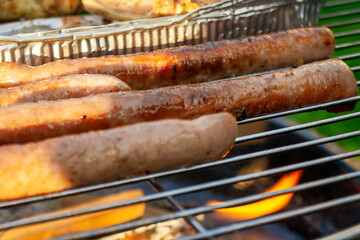tasty bratwurst sausage barbecuing on the grill