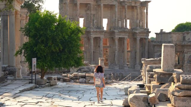 Celcus library at Ephesus ancient city Izmir Turkey. The tourist, American woman with white backpack and camera travels there.