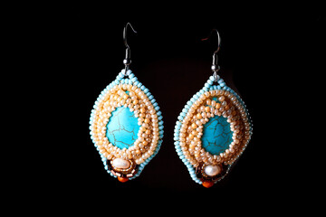 Turquoise earrings with beads at dark