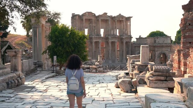 Celcus library at Ephesus ancient city Izmir Turkey. The tourist, American woman with white backpack and camera travels there.
