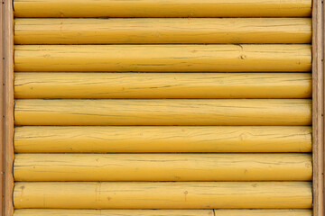 The wall of the building is made of wooden logs painted with yellow paint. A modern building in classical Slavic architecture