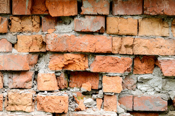 A wall of very old brick red-orange and brown with destruction. Texture