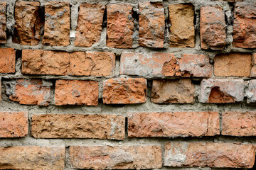 A wall of very old brick red-orange and brown with destruction. Texture