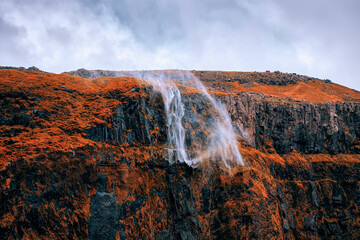Water from waterfall being blown away by
storm winds off the steep cliff located in nearby Seljalandsfoss in Southern Iceland.