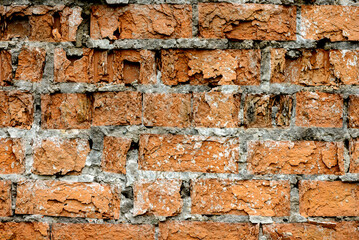 A wall of very old brick red-orange and brown with destruction. Texture