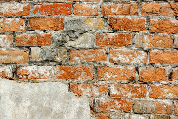 A wall of very old brick red-orange and brown with destruction. Texture