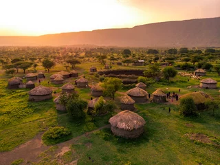Fotobehang Afrika Aerial Drone Shot. Traditional Masai village at Sunset time near Arusha, Tanzania  © Oleksandr