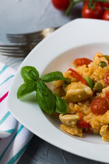 Paella with chicken breast, red pepper and cocktail tomatoes.