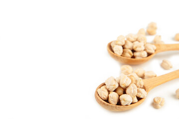 Uncooked chickpeas in wooden spoons isolated on white background