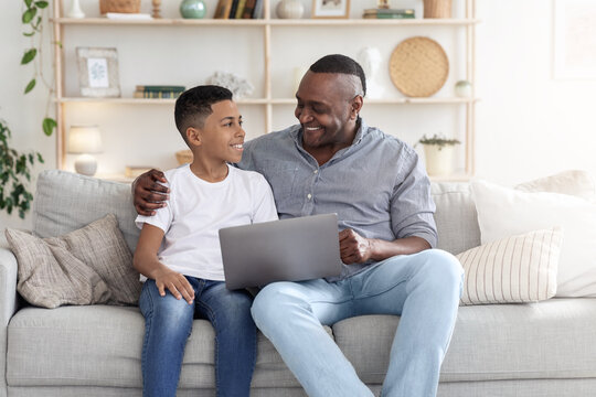 Black Preteen Boy Teaching His Grandfather How To Use Laptop