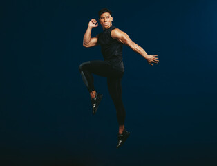 Fototapeta na wymiar Sportsman doing jumping and stretching workout