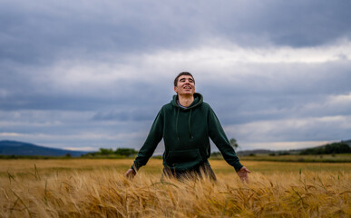 a boy in sportswear in a wheat field walks and runs happily into a sunset.