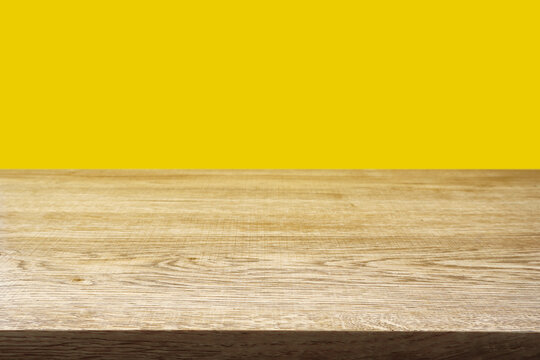 Wood table on yellow background.