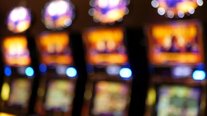 Defocused slot machines glow in casino on fabulous Las Vegas Strip, USA. Blurred gambling jackpot slots in hotel near Fremont street. Illuminated neon fruit machine for risk money playing and betting.