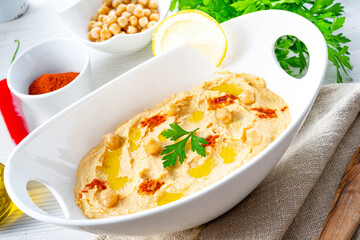 hummus paste with lemon and chilli on white background