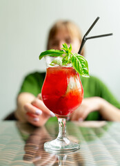 Girl stretching out for a glass of strawberry basil cocktail
