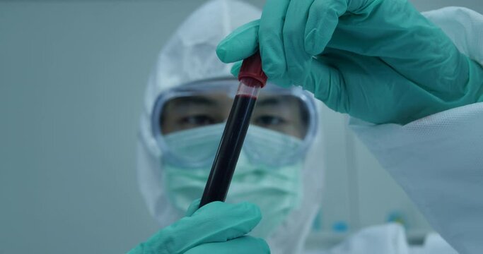 Medical examiner holds a blood sample vial at an Indian testing lab for treating coronavirus cases