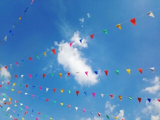 Colorful pennant bunting flags against blue sky background.