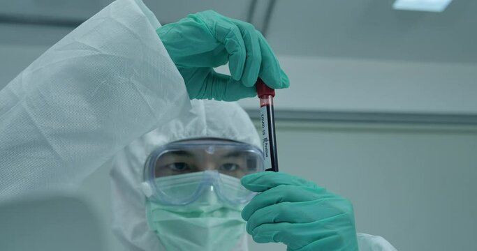 Medical examiner holds a blood sample vial at an Indian testing lab for treating coronavirus cases