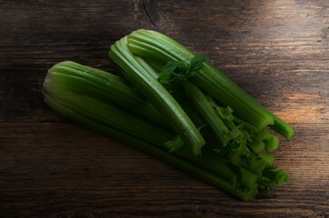 Bunch of fresh celery stalk with leaves on old wooden background