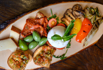 Antipasti on wood  plate at  Italian restaurant.