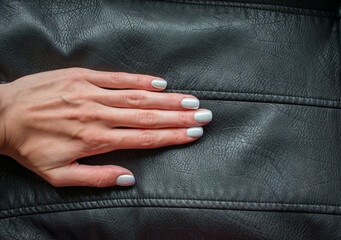 Manicure with shiny pearl nail polish, light color. Powder for design. Holographic hue. Woman hand...